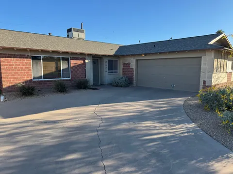 Ranch-style home with red brick and freshly painted trim, fascia, and garage door