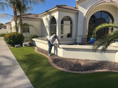Painter prepping a courtyard stucco wall on a custom Santa Barbara-style Phoenix-area home