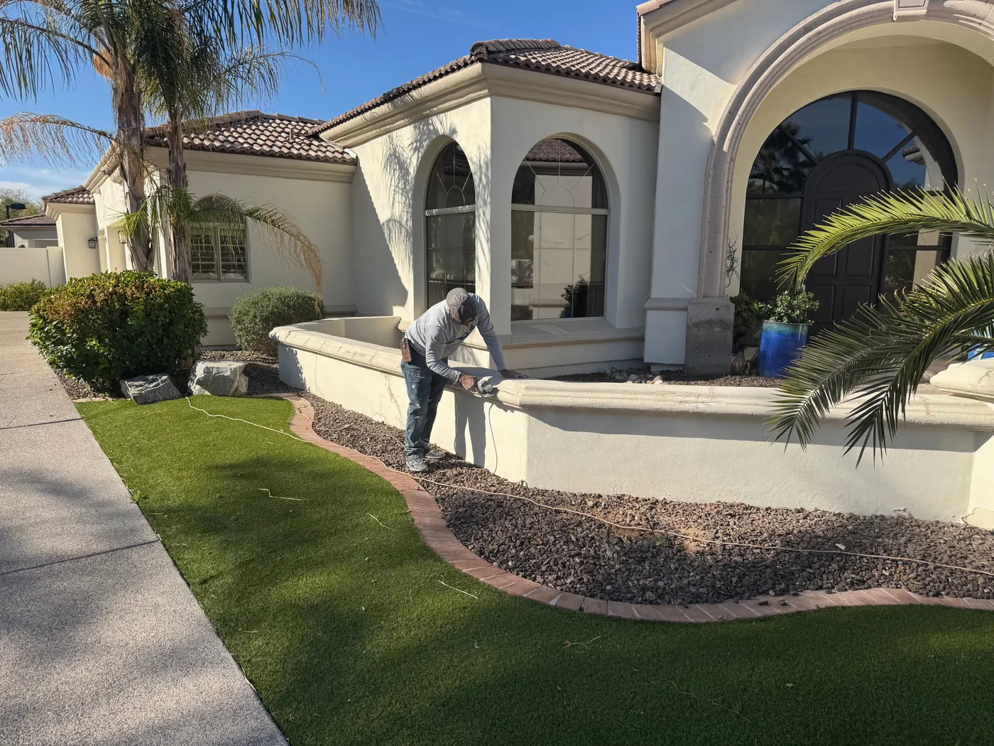 Maricopa Valley Painting painter spraying a stucco wall during a full exterior repaint in the Phoenix area